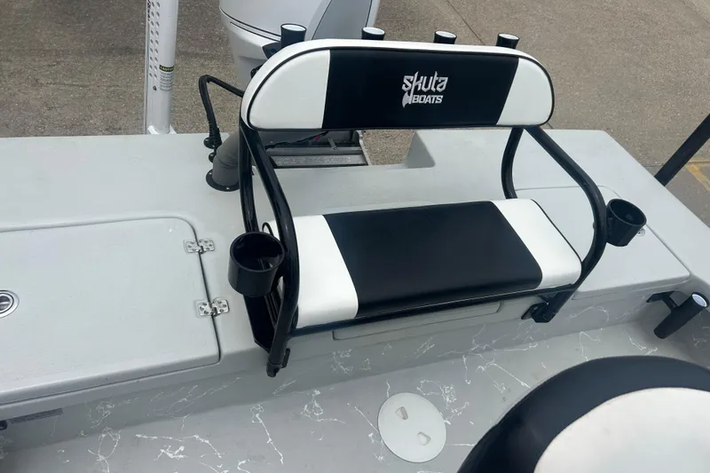 Slide: The Image of 2025 Skuta 24 boat seat with black and white design, featuring cup holders. - 17