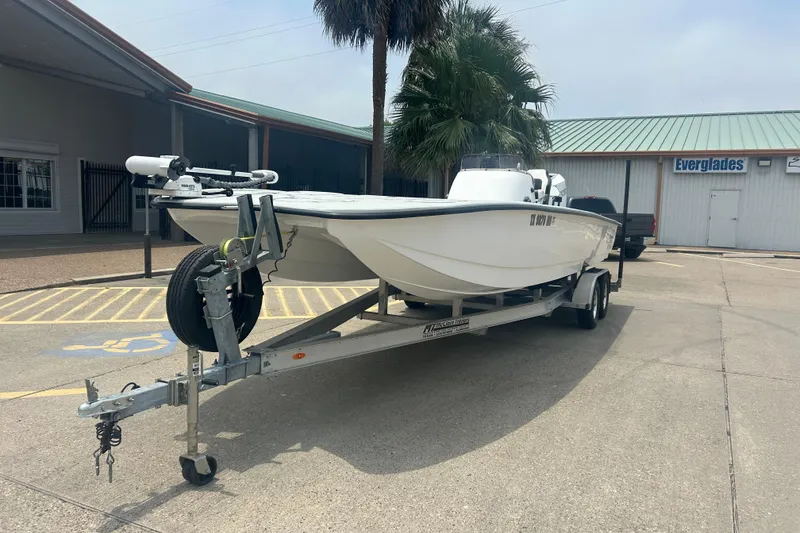 Slide: The Image of 2025 Skuta 24 boat on trailer in parking lot near Everglades building. - 2