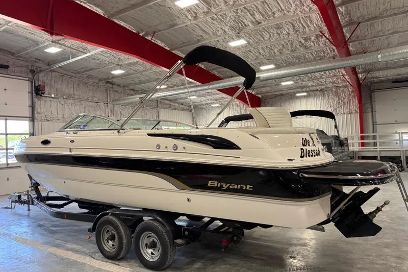 Slide: The Image of 2007 Bryant boat in indoor storage, featuring sleek design and dual-axle trailer. - 4