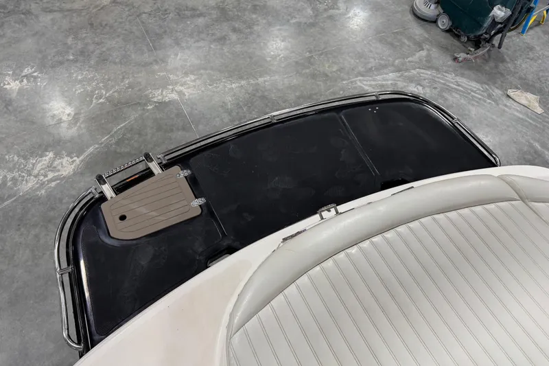 Slide: The Image of 2007 Bryant boat interior with white seating and black platform in a garage setting. - 6