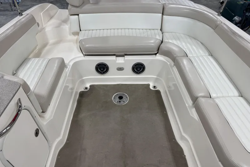 Slide: The Image of 2007 Bryant boat interior with white and beige seating, carpeted floor, and built-in speakers. - 8