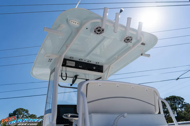 Slide: The Image of 2026 Sea Hunt Ultra 265 SE boat console with rod holders and speakers under a clear blue sky. - 21