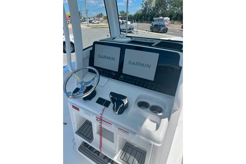 Slide: The Image of 2026 Sea Hunt Ultra 265 SE boat dashboard with Garmin displays and steering wheel. - 40
