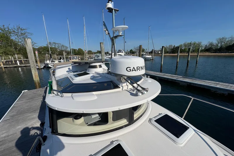 Slide: The Image of 2026 Ranger Tugs R-25 docked, featuring Garmin navigation equipment, under clear blue skies. - 11