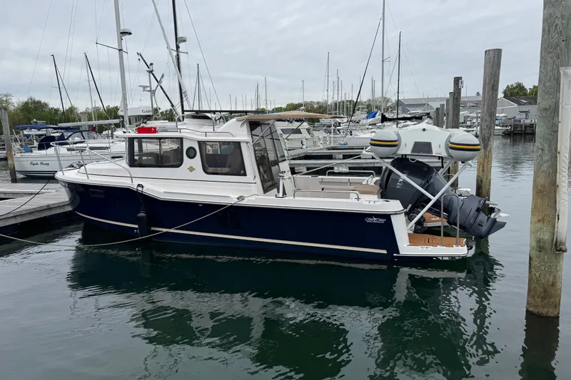 Slide: The Image of 2026 Ranger Tugs R-25 boat docked in a marina, showcasing sleek design and modern features. - 2