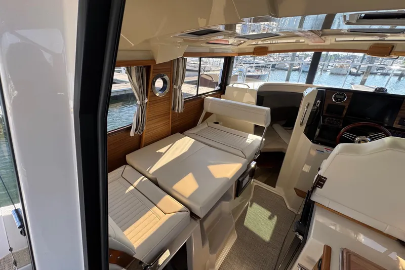Slide: The Image of Interior of 2026 Ranger Tugs R-25 boat, featuring seating and helm, dockside view. - 20
