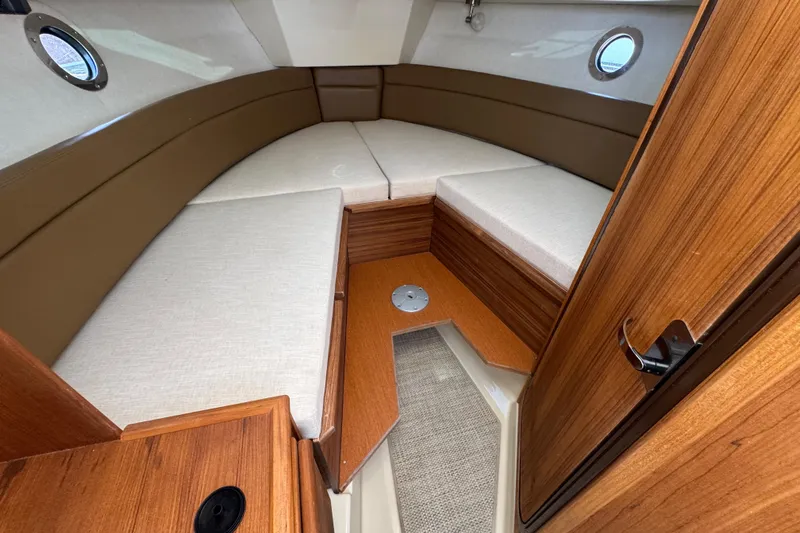 Slide: The Image of Interior cabin of 2026 Ranger Tugs R-25 with wood finish and cushioned seating. - 21
