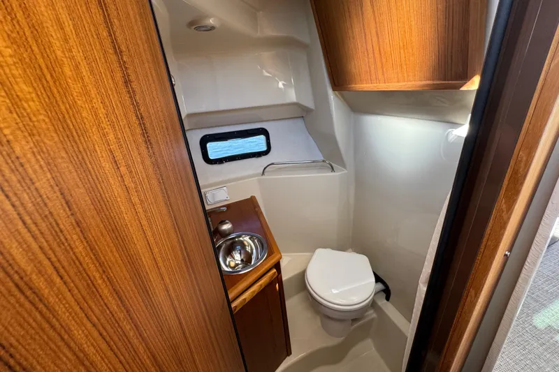 Slide: The Image of 2026 Ranger Tugs R-25 boat bathroom with wood accents and compact design. - 25