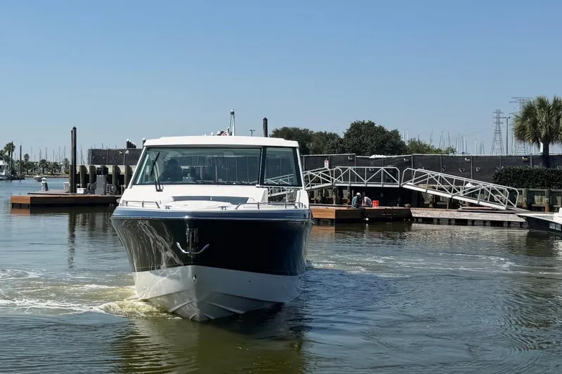 Slide: The Image of 2026 Formula 380 Super Sport Crossover OB boat docked in a marina. - 2