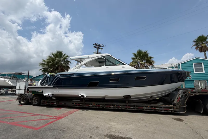 Slide: The Image of 2026 Formula 380 Super Sport Crossover OB boat on trailer under clear sky. - 6