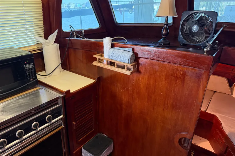 Slide: The Image of Interior of 1978 Albin 36 Trawler with wooden cabinetry, microwave, and fan. - 18