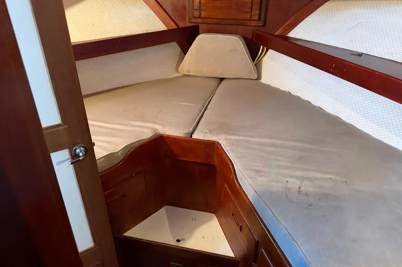 Slide: The Image of 1978 Albin 36 Trawler cabin interior with V-berth and wooden accents. - 19