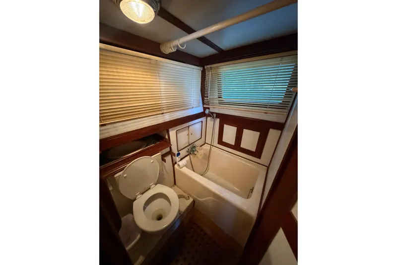 Slide: The Image of Bathroom interior of 1978 Albin 36 Trawler with toilet, bathtub, and blinds. - 24