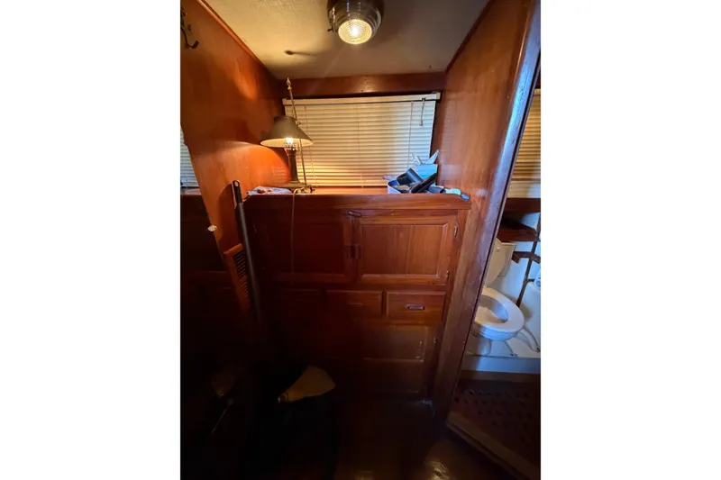 Slide: The Image of Interior of 1978 Albin 36 Trawler with wooden cabinetry and a small bathroom. - 25