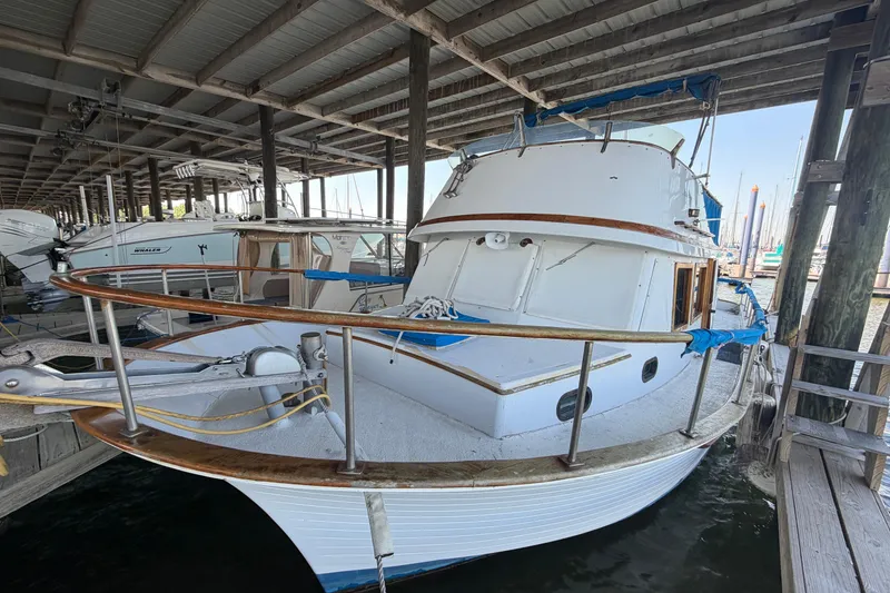 Slide: The Image of 1978 Albin 36 Trawler docked under a covered marina, showcasing classic nautical design. - 3