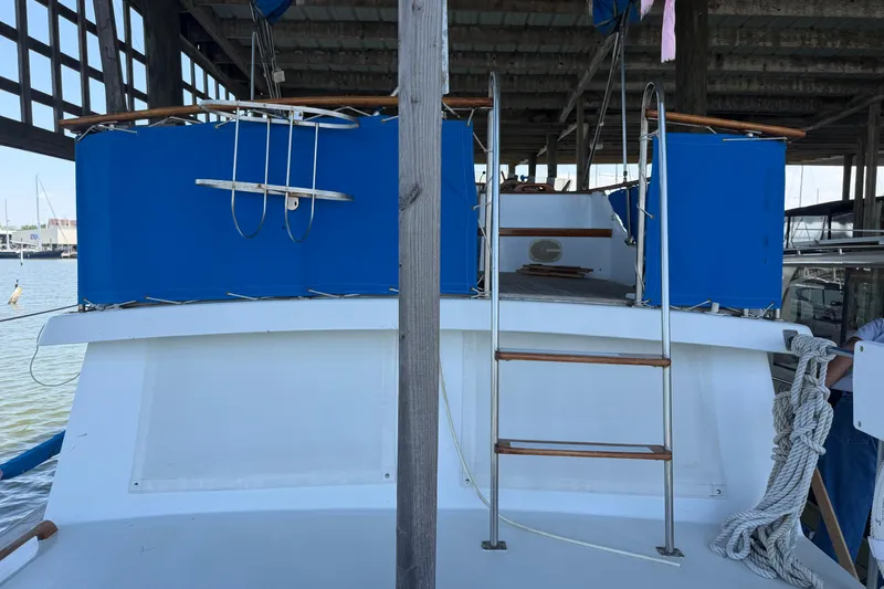 Slide: The Image of 1978 Albin 36 Trawler with blue covers and ladder, docked in a marina. - 4