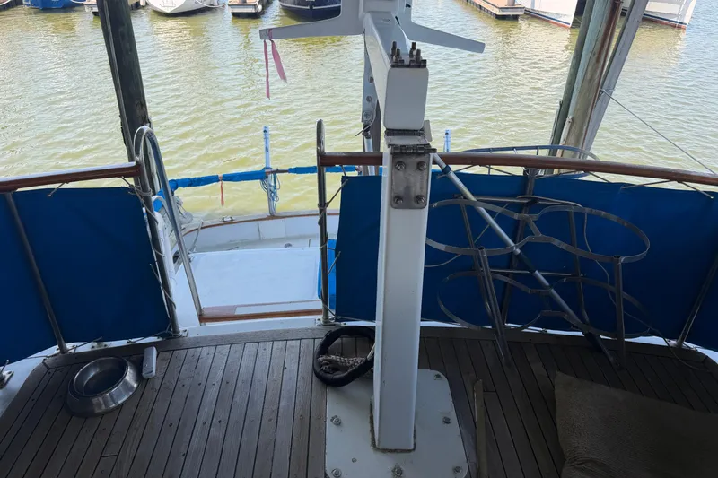 Slide: The Image of 1978 Albin 36 Trawler deck with blue railings and wooden flooring, docked at marina. - 8
