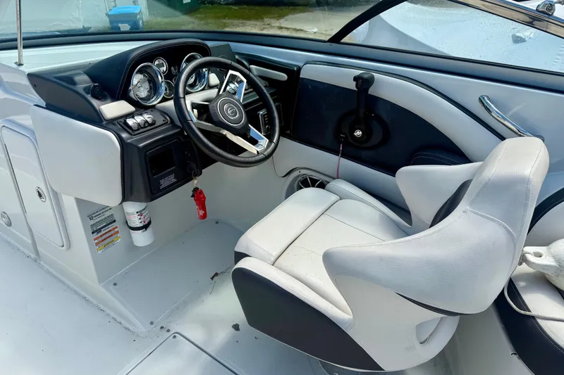 Slide: The Image of 2020 Crownline Eclipse E235 boat cockpit with steering wheel and captain's chair. - 11
