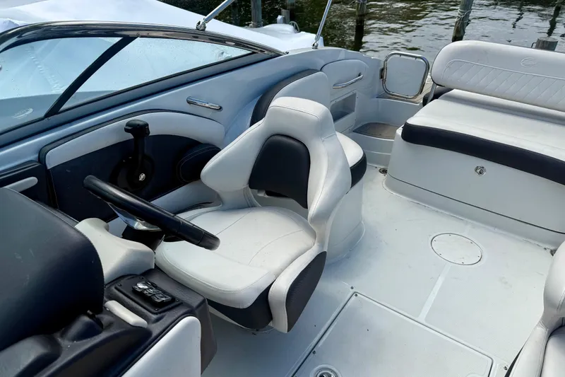 Slide: The Image of 2020 Crownline Eclipse E235 boat interior with white seating and steering wheel. - 13