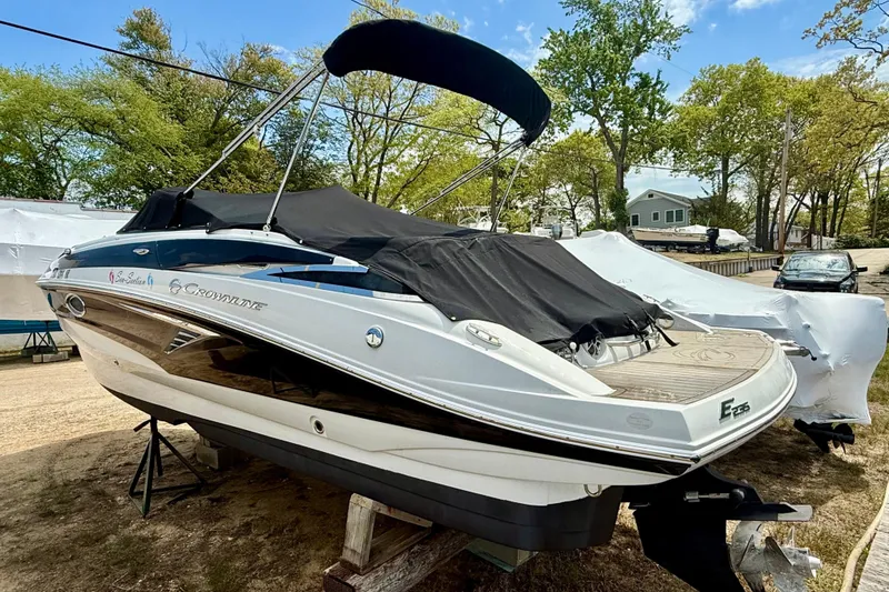 Slide: The Image of 2020 Crownline Eclipse E235 boat with cover, parked outdoors on a sunny day. - 20
