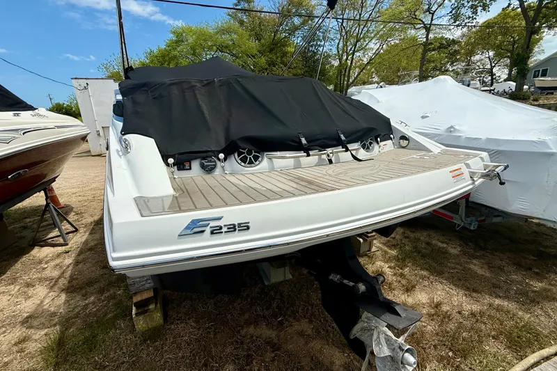 Slide: The Image of 2020 Crownline Eclipse E235 boat with covered deck, parked outdoors. - 21