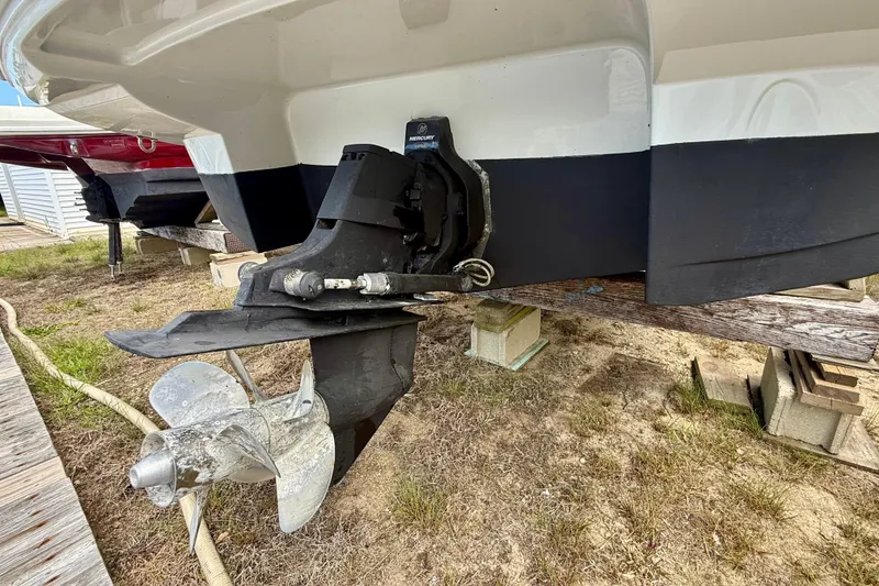 Slide: The Image of 2020 Crownline Eclipse E235 boat stern with Mercury outdrive on wooden supports. - 23