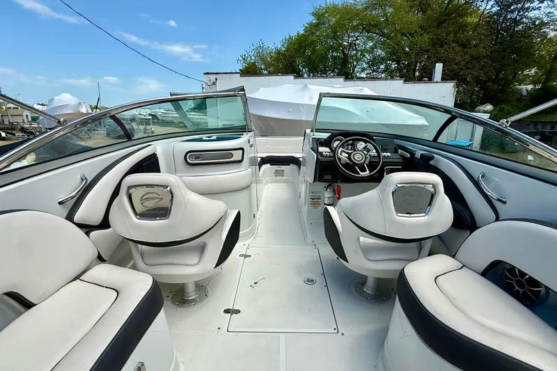 Slide: The Image of 2020 Crownline Eclipse E235 boat interior with white seating and steering wheel. - 28