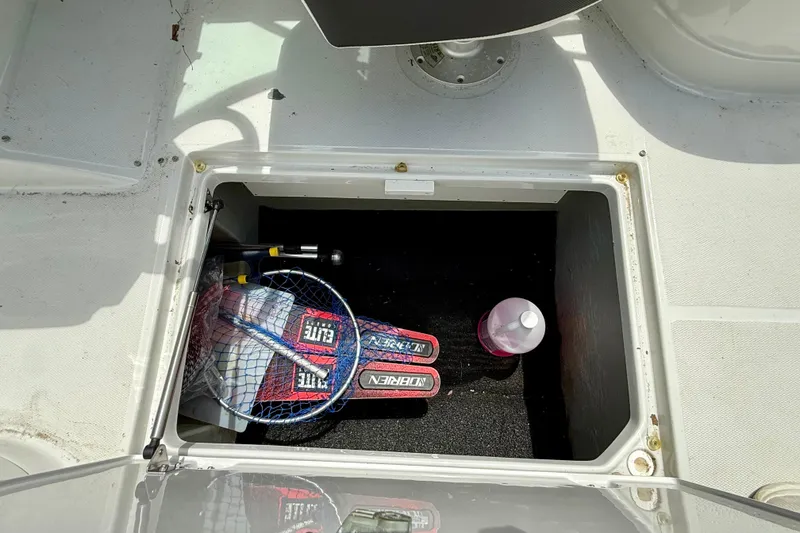Slide: The Image of Storage compartment on a 2020 Crownline Eclipse E235 boat with fishing gear and bottle. - 31