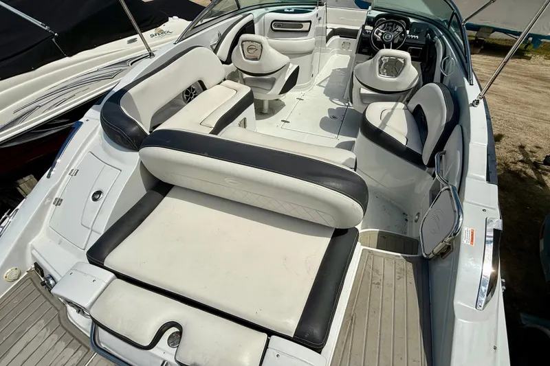 Slide: The Image of 2020 Crownline Eclipse E235 boat interior with white and black seating, steering wheel, and spacious layout. - 37