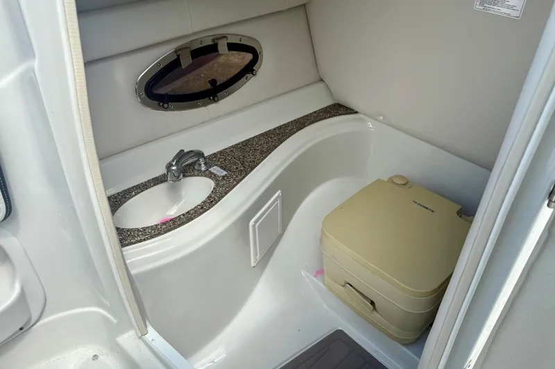 Slide: The Image of 2020 Crownline Eclipse E235 boat interior with sink and portable toilet. - 6
