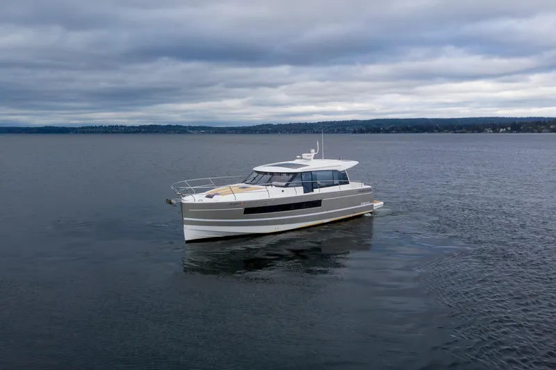 The Image of 2017 Jeanneau NC 14 yacht cruising on a calm, overcast sea. - 0