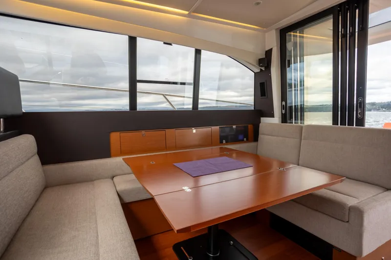 Slide: The Image of Luxurious interior of 2017 Jeanneau NC 14 yacht with elegant seating and panoramic windows. - 10