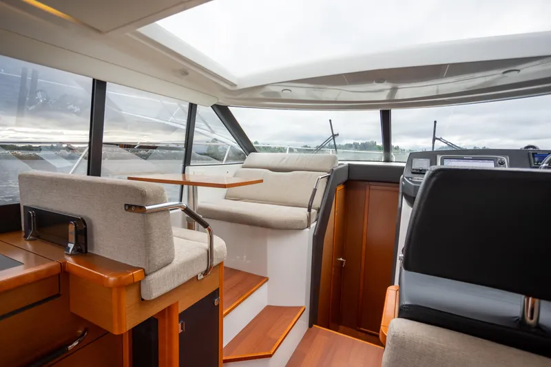 Slide: The Image of Interior of 2017 Jeanneau NC 14 yacht with modern seating and panoramic windows. - 14