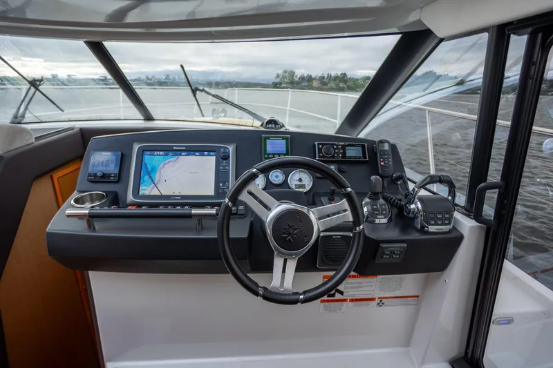 Slide: The Image of Cockpit of 2017 Jeanneau NC 14 boat with navigation equipment and steering wheel. - 15