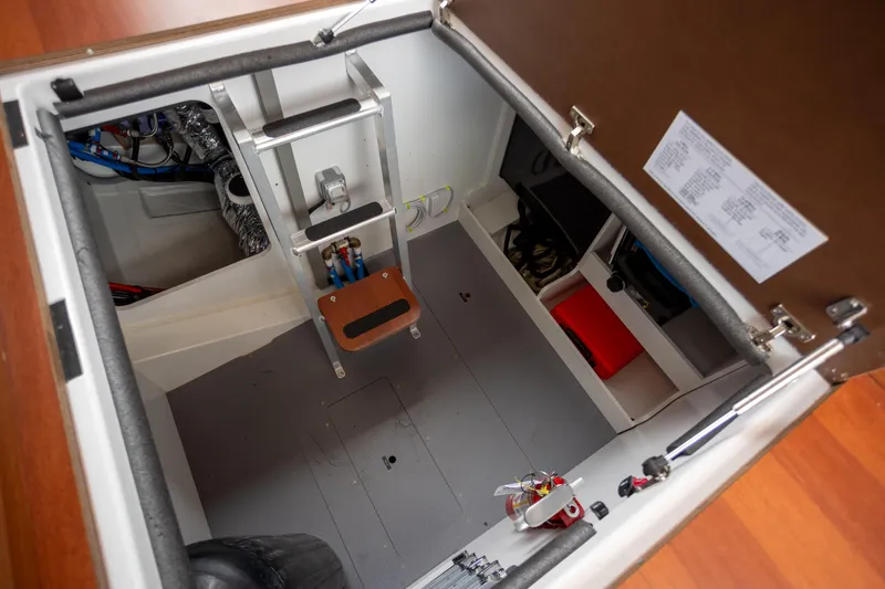 Slide: The Image of Engine compartment of 2017 Jeanneau NC 14 boat, featuring organized storage and access ladder. - 21