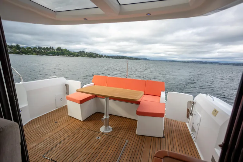 Slide: The Image of Spacious deck of 2017 Jeanneau NC 14 yacht with orange seating and wooden flooring. - 6