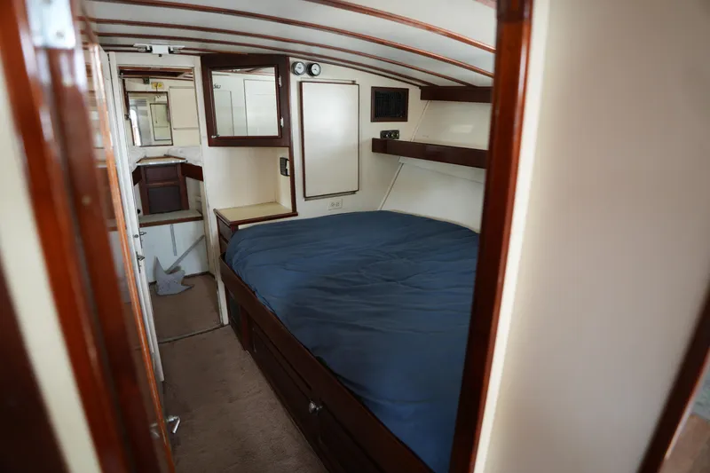 Slide: The Image of Cozy cabin interior of a 1960 Matthews 42 Stock Cruiser with wooden accents and a blue bedspread. - 25