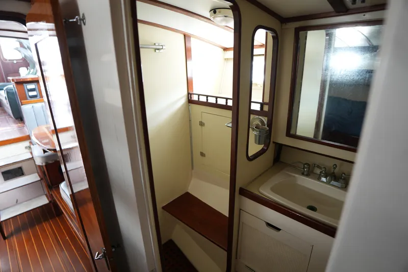 Slide: The Image of Interior of 1960 Matthews 42 Stock Cruiser, featuring a compact bathroom with wooden accents. - 29