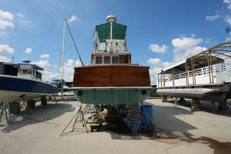 Slide: The Image of 1960 Matthews 42 Stock Cruiser on dry dock, surrounded by other boats under a clear sky. - 3