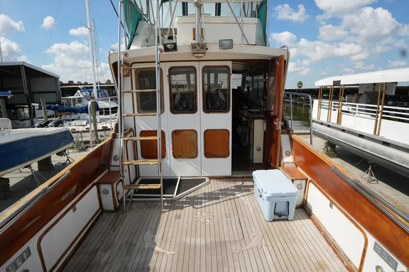 Slide: The Image of 1960 Matthews 42 Stock Cruiser boat deck with wooden finish and ladder, docked at marina. - 5