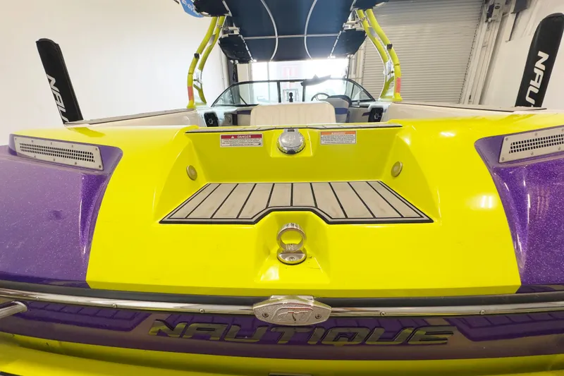 Slide: The Image of 2014 Nautique Ski Nautique 200 Closed Bow, vibrant yellow and purple design, rear view. - 6