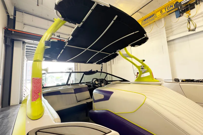Slide: The Image of 2014 Nautique Ski Nautique 200 Closed Bow boat with vibrant interior and canopy in a garage. - 12