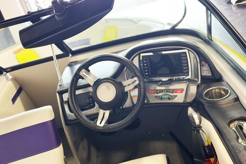Slide: The Image of Interior of a 2014 Nautique Ski Nautique 200 boat, featuring steering wheel and control panel. - 9