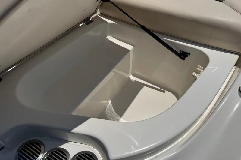 Slide: The Image of Open storage compartment in a 2006 Chaparral 256 SSi boat, featuring clean white interior. - 11