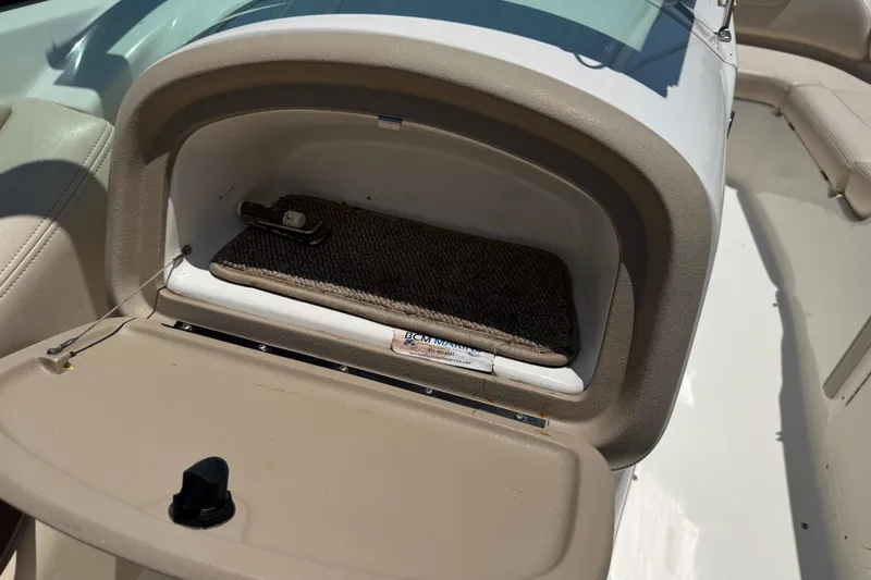 Slide: The Image of Open glove compartment in 2006 Chaparral 256 SSi boat, showing interior storage space. - 24