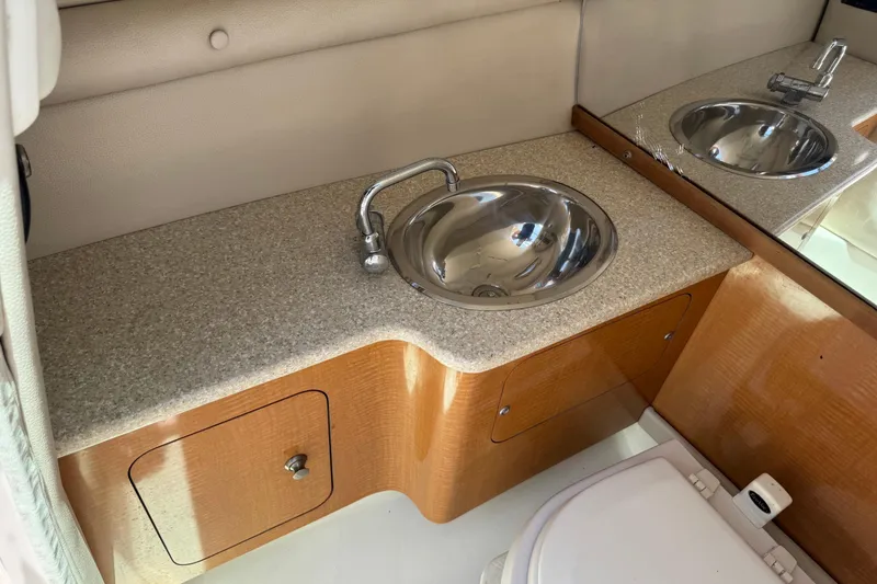 Slide: The Image of 2006 Chaparral 256 SSi boat interior with sink and wooden cabinetry. - 27