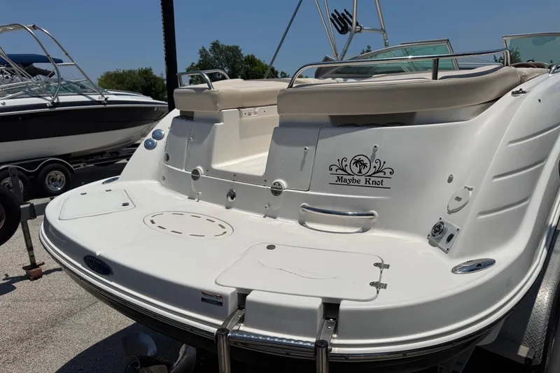 Slide: The Image of 2006 Chaparral 256 SSi boat with "Maybe Knot" decal, docked under clear skies. - 6