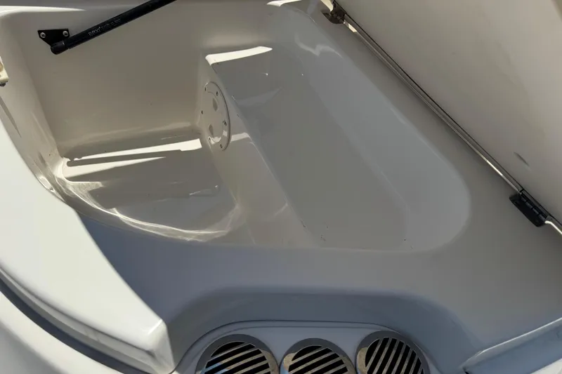 Slide: The Image of Open storage compartment in a 2006 Chaparral 256 SSi boat, featuring clean white interior. - 9