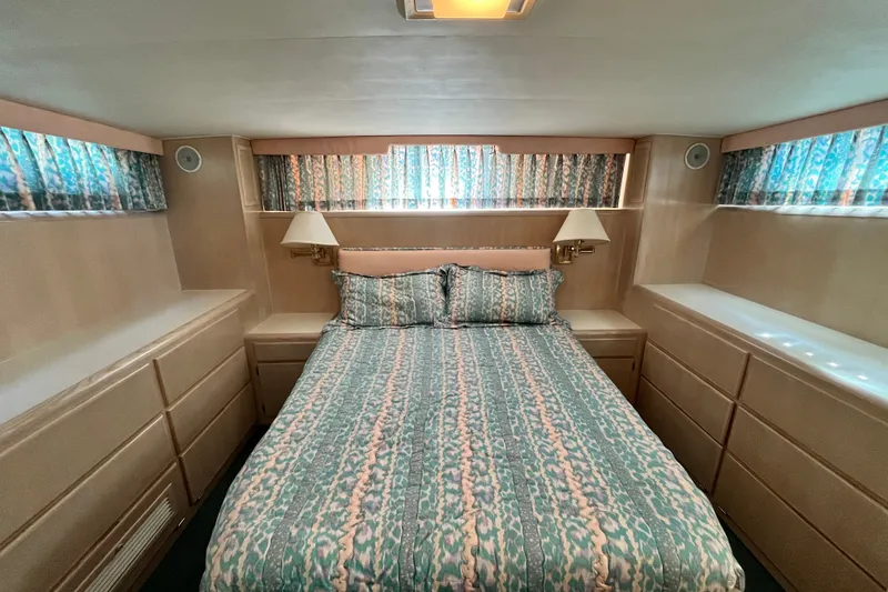 Slide: The Image of Cozy bedroom in 1991 Hatteras 40 Double Cabin yacht with patterned bedding and ample storage. - 19