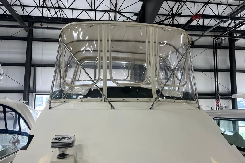 The Image of 1991 Hatteras 40 Double Cabin yacht in a marina, showcasing its enclosed helm area. - 1